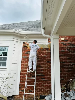 Painter working on exterior porch column during painting project